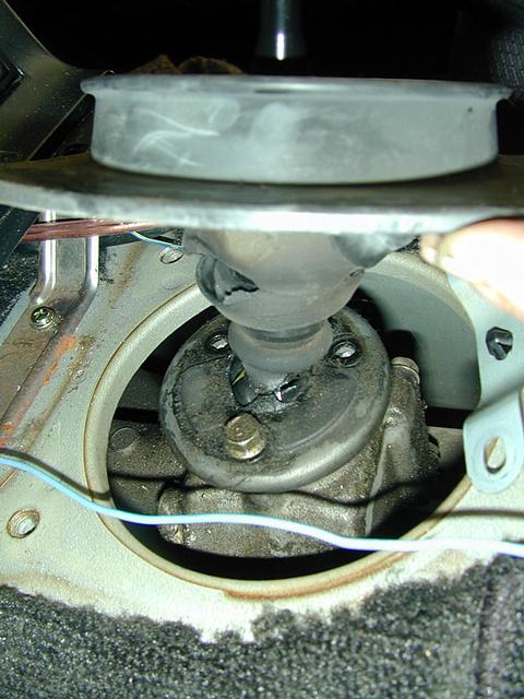 Lifting up the boot and plate shows the three bolts holding the shifter in. Unbolt them.